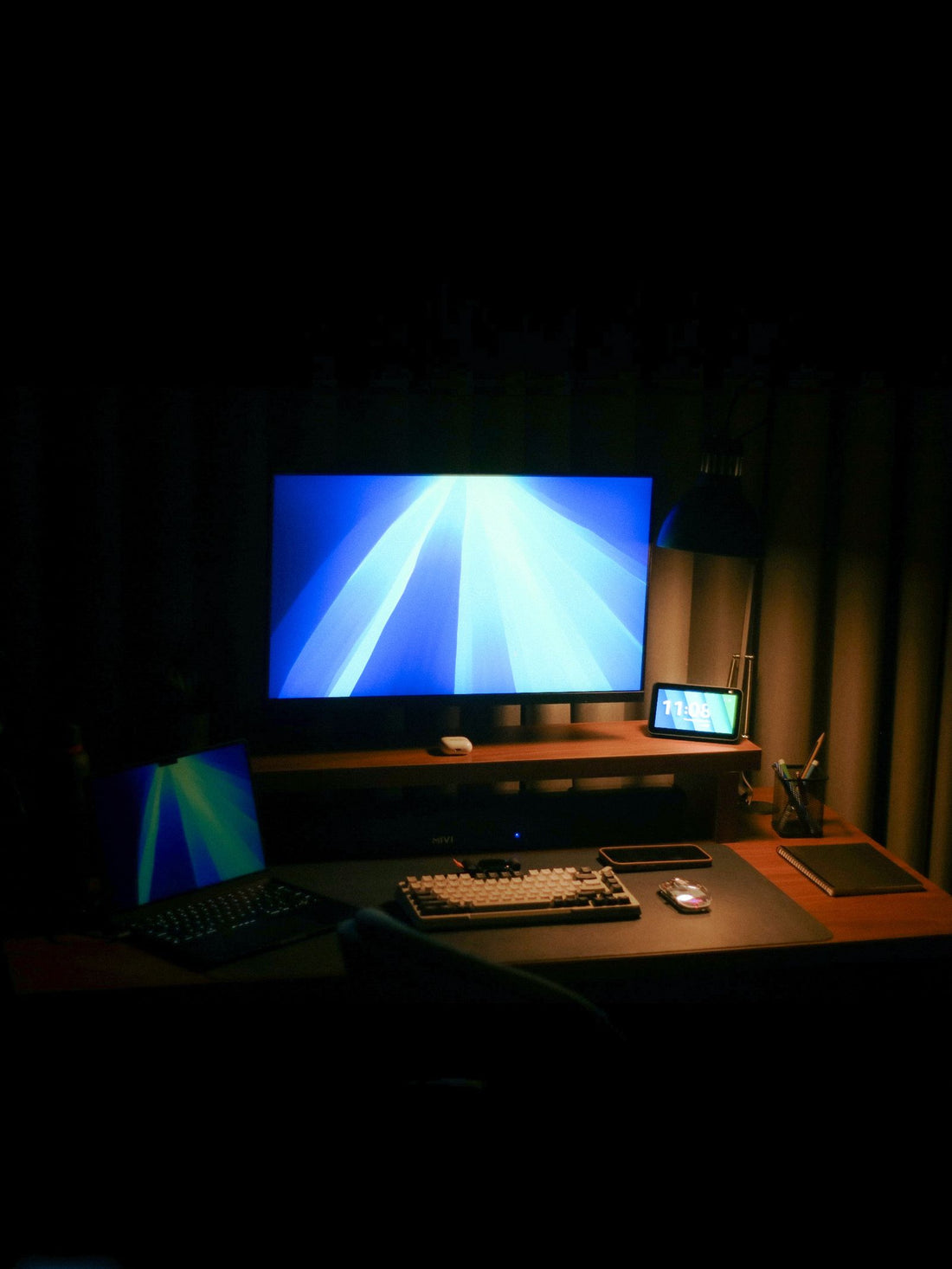 A desk setup with monitors in a dark room
