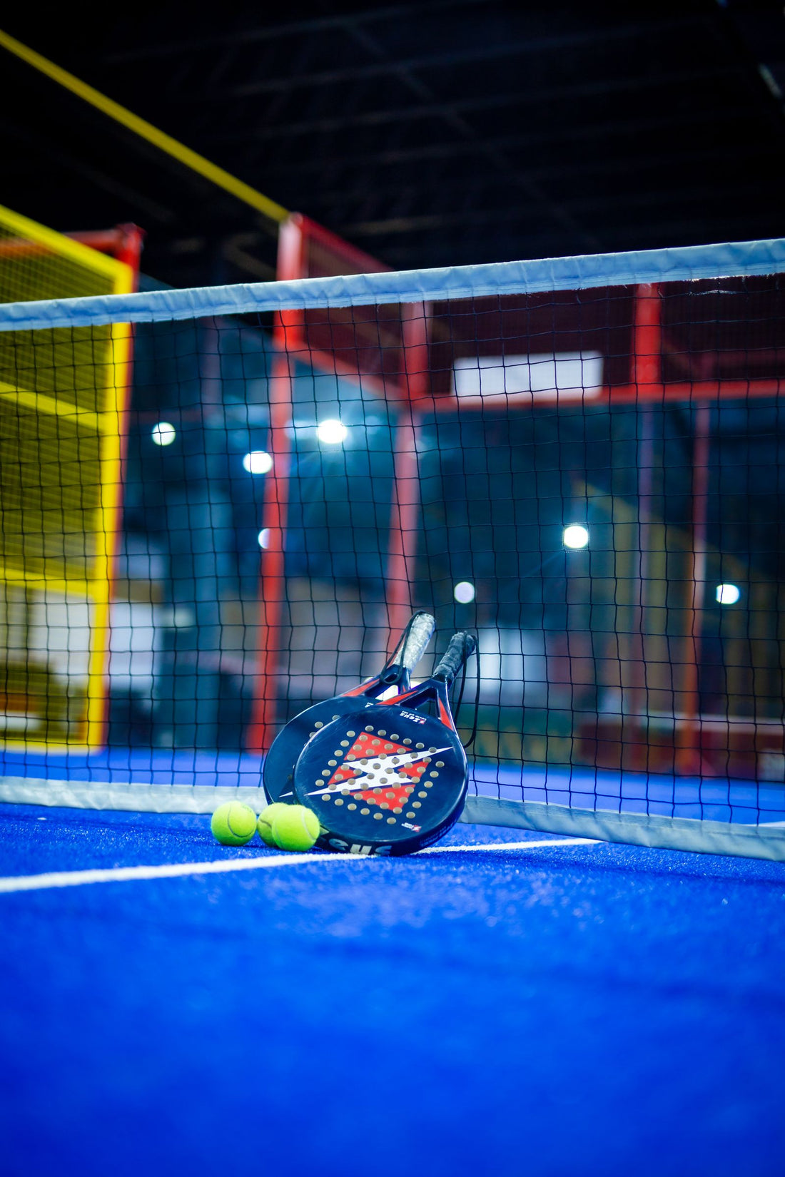 An indoor padel court with racket and balls