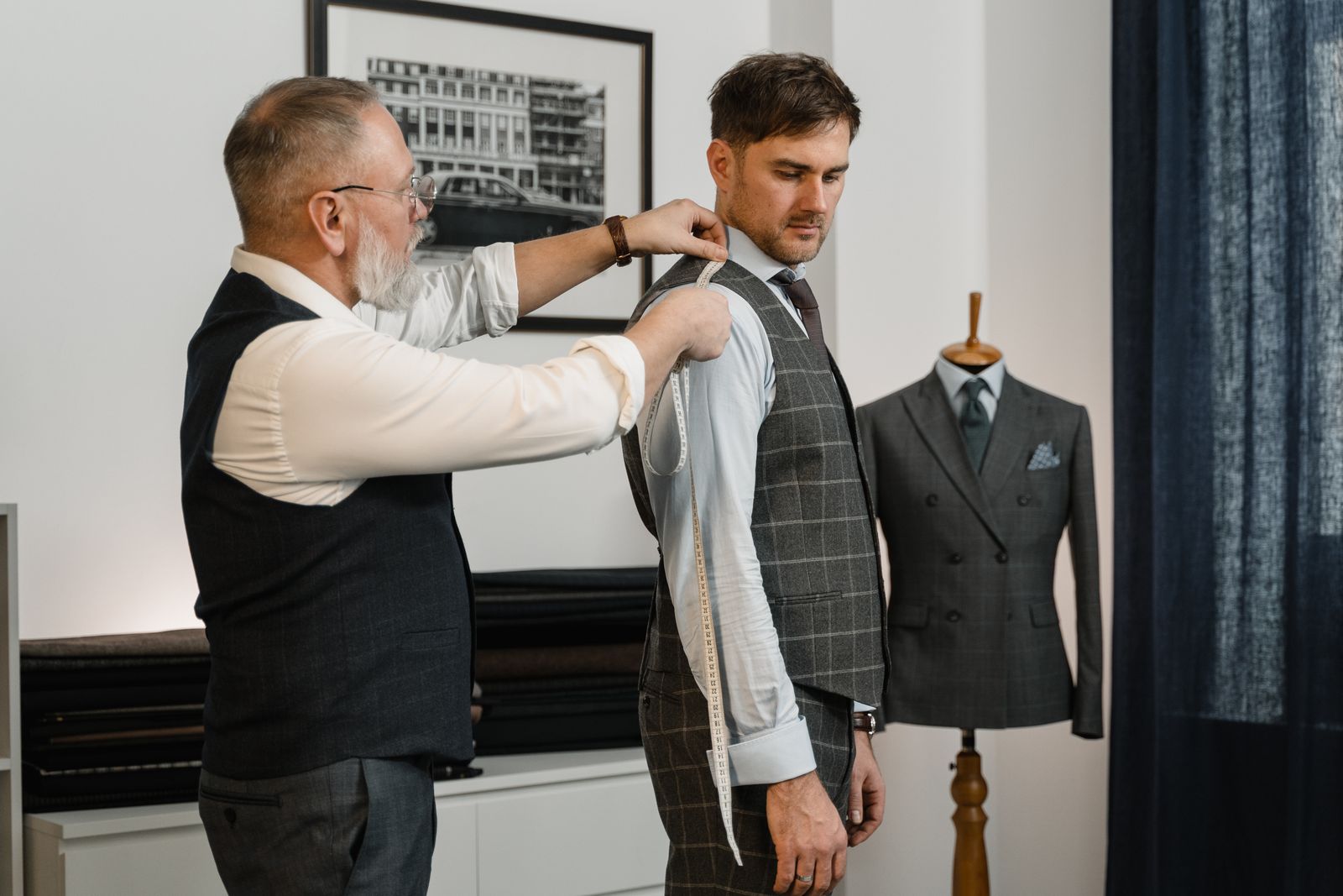 A tailor measuring a client for a suit