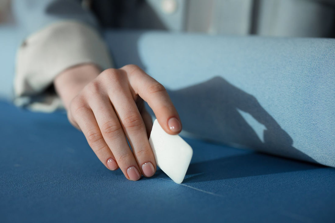 A tailor marking a suit with chalk