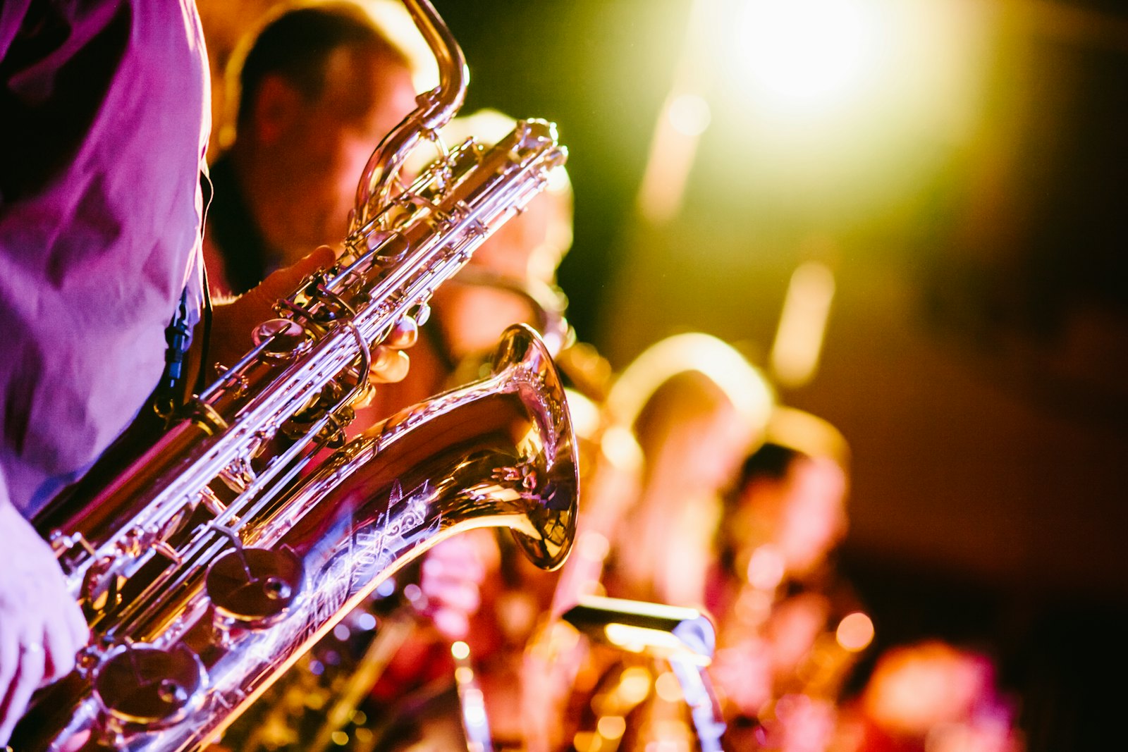 A saxophonist under colored stage lights